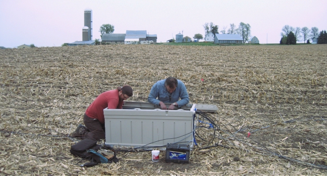This image shows two ARS researchers setting up a system to automatically measure nitrous oxide emissions.